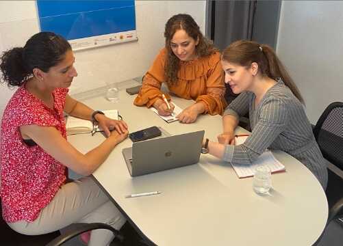 Drei Frauen schauen auf einen Laptop