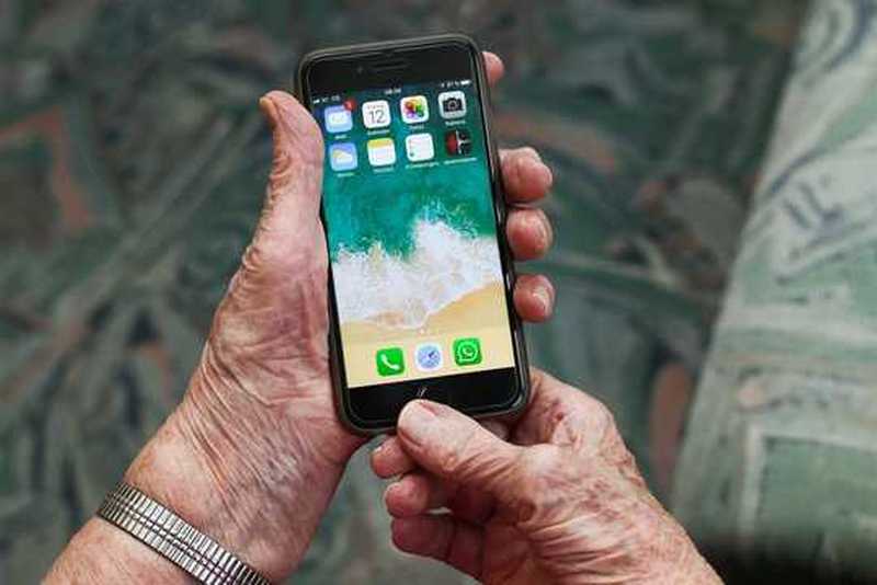 Mobiltelefon in den Händen einer älteren Person